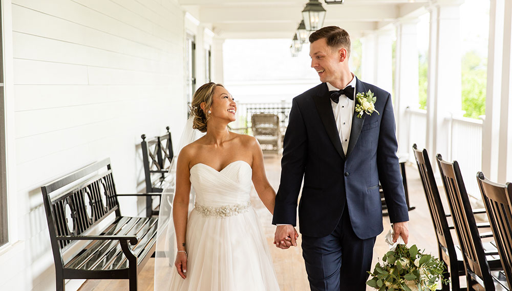 Bride and groom holding hands on Kimpton Taconic Hotel front porch 