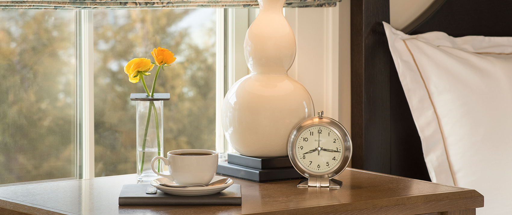 coffee and clock on a bedside table