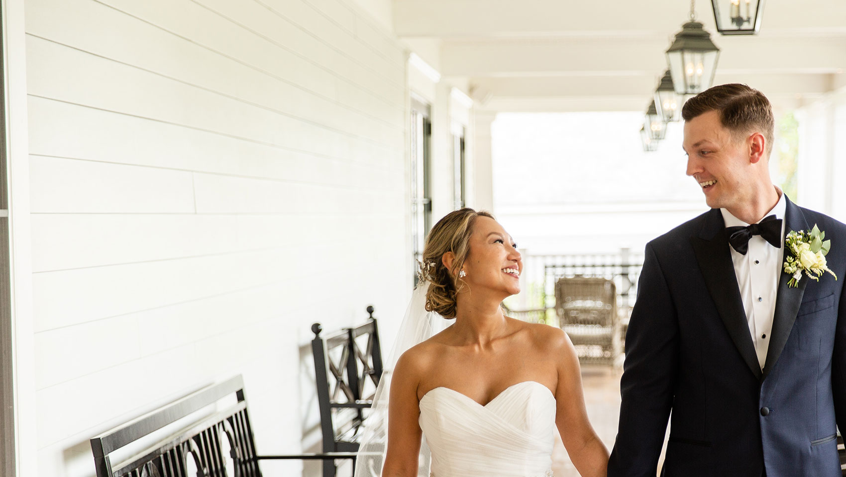 Bride and groom holding hands on Kimpton Taconic Hotel front porch