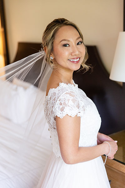 Bride smiling in wedding dress with veil