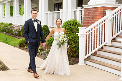 Bride and groom holding hands in front of Kimpton Taconic Hotel entrance