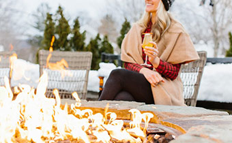 woman holding a champagne glass by the firepit